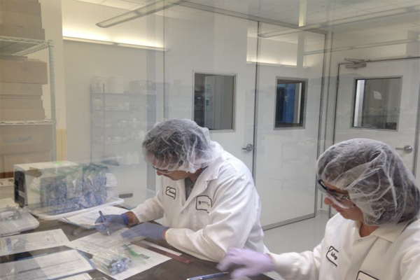 Two people working in a lab conducting topical drug product formulation experiments.