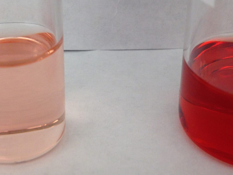 A topical drug product formulation with a red liquid and a pink liquid next to each other.