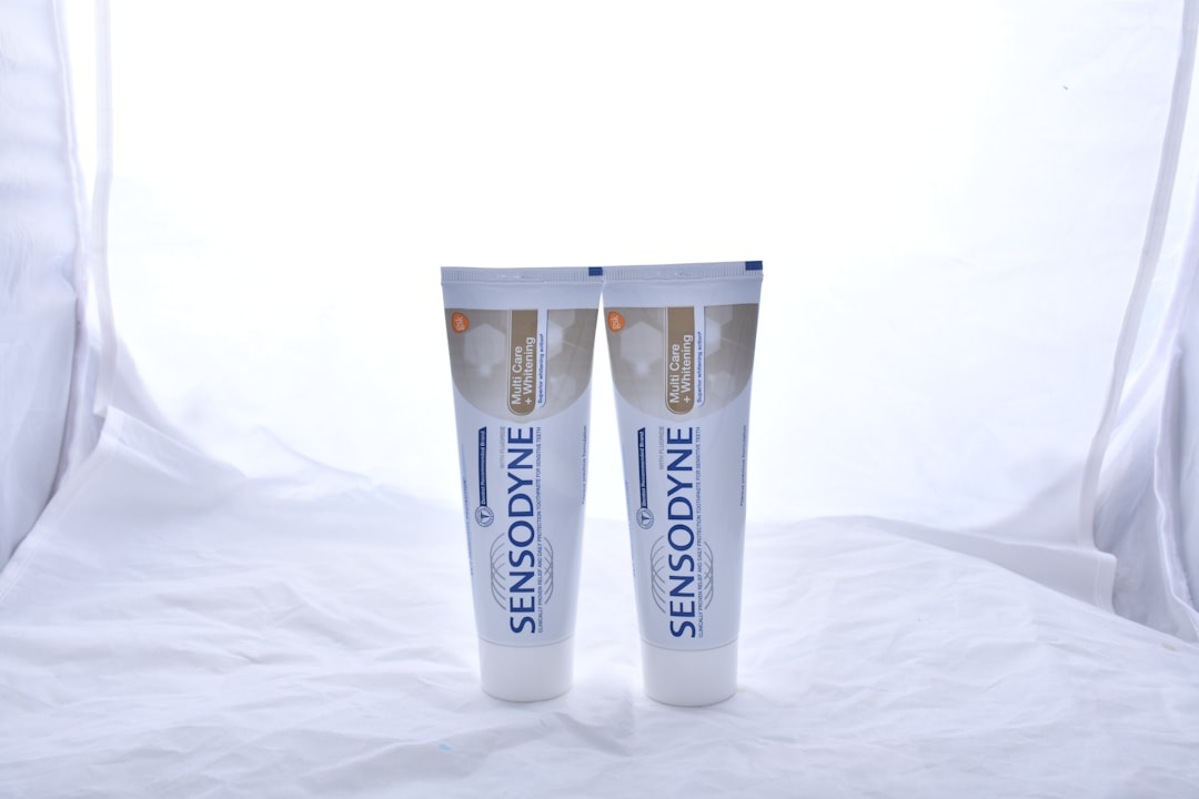 Two tubes of Sensodyne toothpaste stand upright side by side against a white background, reflecting the precision found in pharmaceutical formulation consulting.